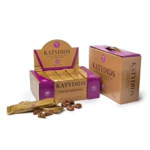 Katydids candy packaging featuring a display box, individual wrapped chocolates, and a bulk box, with caramel and pecan chocolates arranged in the foreground.