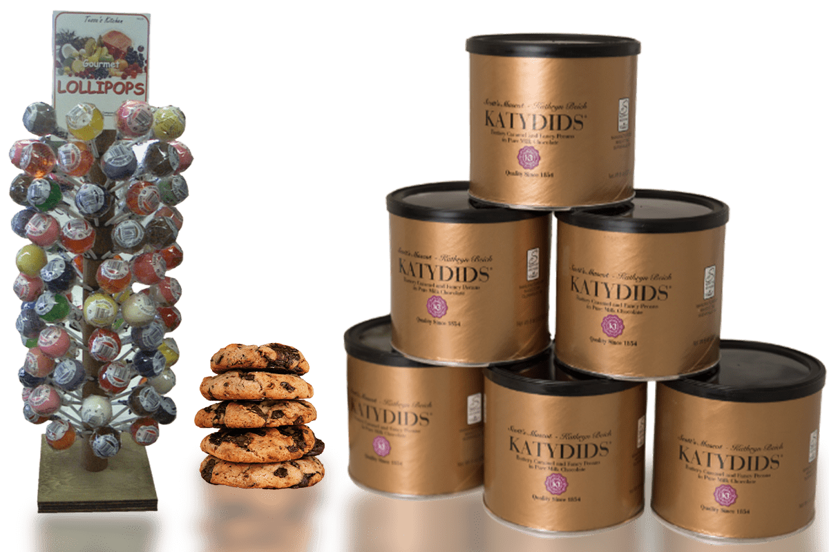 A display of gourmet fundraising treats including a tree of assorted lollipops, a stack of chocolate chip cookies, and multiple tins of Katydids caramel and chocolate confections.