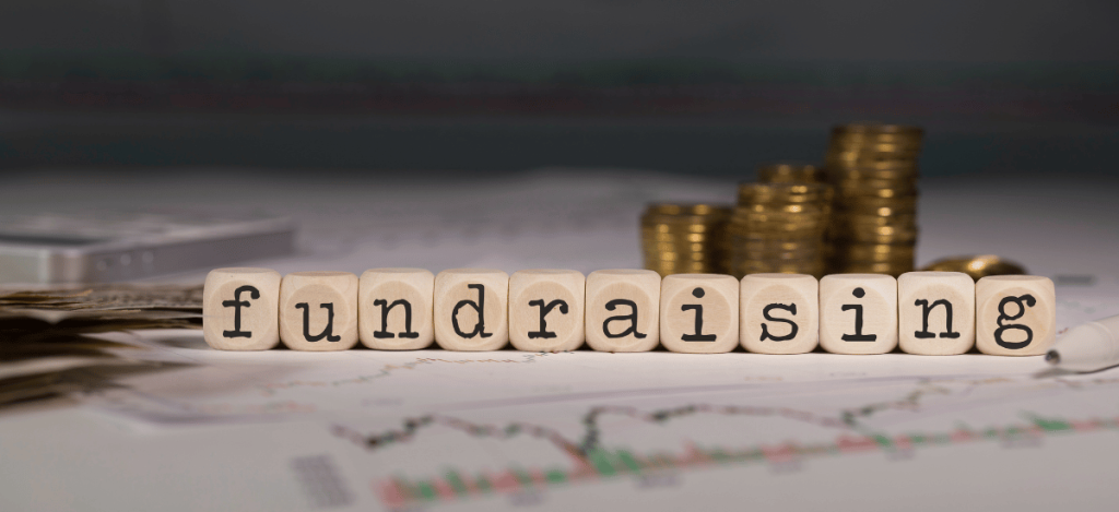 Fundraising Tips written in letter blocks with coins and financial charts in the background.