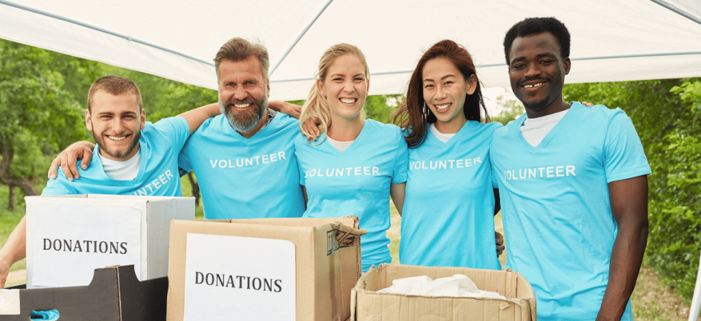 Volunteers organizing donations for school fundraising under a tent.